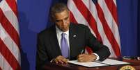 <p>O presidente dos EUA, Barack Obama, assina uma ordem executiva para reforçar a segurança dos cartões de crédito, em Washington, em 17 de outubro</p>  Foto: Larry Downing / Reuters
