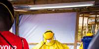 <p>Um agente de saúde vestido com equipamento de proteção é pulverizado com desinfetante após trabalhar em um centro de tratamento de Ebola no oeste de Freetown, Serra Leoa, em 16 de outubro</p>  Foto: Michael Duff / AP