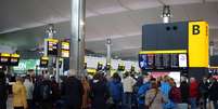 Pessoas fazem filas enquanto aguardam no aeroporto de Heathrow, em Londres, após voos serem cancelados  Foto: Steve Parsons / AP