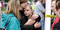 <p>Estudantes e familiares se confortam após tiroteio em colégio em Marysville, nos Estados Unidos, no dia 24 de outubro</p>  Foto: Jason Redmond / Reuters