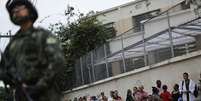 <p>Soldado em porta de colégio no Complexo da Maré, Rio de Janeiro</p>  Foto: Leo Correa / AP