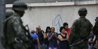 Soldados fazem a segurança em porta de colégio no Complexo da Maré, Rio de Janeiro  Foto: Leo Correa / AP