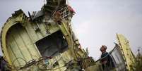 Investigador observa os destroços do avião da Malaysia Airlines que caiu perto de Grabovo, leste da Ucrânia. 22/07/2014  Foto: Maxim Zmeyev / Reuters