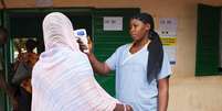 <p>Profissional de saúde verifica temperatura em mulher que deixou Guiné, na fronteira com Mali , em Kouremale</p>  Foto: Joe Penney / Reuters