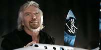 <p>Richard Branson, fundador da Virgin Galactic, com uma miniatura da SpaceShipTwo</p>  Foto: Stan Honda / AFP