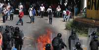 <p>Os manifestantes, que estavam com os rostos cobertos, entraram em confronto com o batalhão de choque</p>  Foto: José Luis de la Cruz / EFE