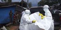<p>Agentes de saúde removem corpo de homem que provavelmente morreu vítima de Ebola na Libéria</p>  Foto: James Giahyue / Reuters