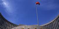 <p>Bandeira da China hasteada em frente à sede do banco central do país, em Pequim</p>  Foto: Petar Kujundzic / Reuters