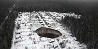 O enorme buraco é visto em imagem aérea - quatro casas foram "engolidas"  Foto: Reuters