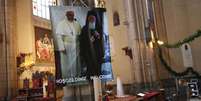 <p>Mulher reza perto de cartaz com fotos do Papa Francisco e do patricarca Bartolomeu em igreja católica no centro de Istambul</p>  Foto: Murad Sezer / Reuters