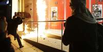 Manifestante joga fogo contra prédio público durante protestos   Foto: Tomas Bravo / Reuters