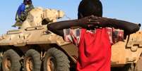 Menino observa comboio militar do governo no Sudão. 20/11/2014.  Foto: Mohamed Nureldin Abdallah / Reuters