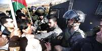 O ministro e ativista é visto na foto em confronto com um guarda israelense nos protestos desta quarta-feira  Foto: ABBAS MOMANI / AFP