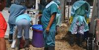 Agentes da saúde entram num centro de tratamento de Ebola, em Monróvia, na Libéria, nesta terça-feira. 16/12/2014  Foto: James Giahyue / Reuters