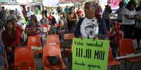 Mãe de estudante desaparecido segura cartaz com a mensagem "Feliz Natal, meu filho. Aonde quer que você esteja"  Foto: Jorge Dan Lopez / Reuters