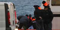 <p>Equipe da guarda costeira italiana carrega um corpo ap&oacute;s chegada ao porto</p>  Foto: Ciro De Luca / Reuters