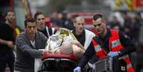 Uma pessoa ferida é socorrida após ataque ao escritório da revista satírica Charlie Hebdo, em Paris, em 7 de janeiro  Foto: Thibault Camus / AP