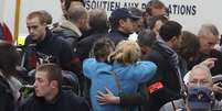 Pessoas se abraçam em frente ao escritório da revista "Charlie Hebdo" após atentado  Foto: Remy de la Mauviniere / AP