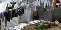 Refugiada síria em acampamento estabelecido no vilarejo de Ketermaya, ao sul de Beirute, no Líbano  Foto: Ali Hashisho  / Reuters