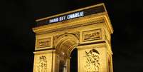 A frase "Paris est Charlie" (Paris é Charlie) pode ser lida em enormes letras na parte superior do monumento de estilo neoclássico  Foto: Youssef Boudlal / Reuters