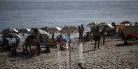 <p>Menino se refresca em chuveiro na praia do Arpoador, no Rio de Janeiro.</p>  Foto: Ricardo Moraes / Reuters