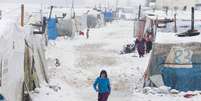 <p>Uma refugiada síria caminha sobre a neve em um acampamento de Bar Elias, no vale de Bekaa, Líbano, em janeiro de 2015</p>  Foto: Mohamed Azakir / Reuters