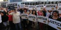 Argentinos exibem cartazes com a palavra "Justiça" em frente à associação judaica AMIA durante protesto para pedir justiça na morte de um promotor argentino envolvido na investigação de um atentado, em Buenos Aires. 21/01/2015  Foto: Marcos Brindicci / Reuters
