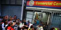 <p>Pessoas fazem fila em porta de mercado no centro de Caracas</p>  Foto: Jorge Silva / Reuters