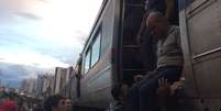 <p>Passageiros se ajudam no momento de descer do trem</p>  Foto: Diovane Zica / vc repórter