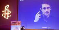 <p>Ex-prestador de serviço da NSA Edward Snowden, que está em Moscou, é visto em telão durante videoconferência realizada pela Anistia Internacional, em 10 de dezembro</p>  Foto: Charles Platiau / Reuters