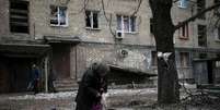 Mulher alimenta pombos diante de casa destruída em Debaltseve, leste da Ucrânia. 05/02/2015.  Foto: Gleb Garanich / Reuters