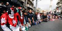 Manifestantes vestidos com a bandeira nacional da Jordânia fazem as orações de sexta-feira antes de uma marcha no centro de Amã, na Jordânia, nesta sexta-feira. 06/02/2015  Foto: Muhammad Hamed / Reuters