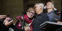 Lee Carter abraça o marido Hollis Johnson ao falar com jornalistas no Supremo Tribunal do Canadá em Ottawa, em 6 de fevereiro. A mãe de Carter, Kay Carter, viajou para a Suíça para morrer em 2010  Foto: Chris Wattie / Reuters