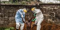 Médicos levam um homem em meio a um delírio induzido pelo ebola para a ala de isolamento de onde tinha escapado  Foto: Pete Muller/Prime for National Geographic/The Washington Post / AP