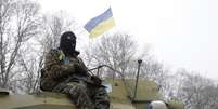 Um soldado ucraniano repousa sobre o seu veículo perto da estrada entre as cidades de Debaltseve e Artemivsk, na Ucrânia, em 16 de fevereiro  Foto: Petr David Josek / AP