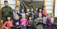 Crianças de um jardim de infância de São Petesburgo, na Rússia, posam com armas ao lado de um militar  Foto: Reprodução / Twitter