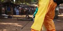 <p>Integrante da Cruz Vermelha desinfeta local onde havia pessoa com suspeita de ebola em Forecariah, na Guin&eacute;</p>  Foto: Misha Hussain / Reuters