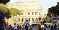 Turistas caminham perto do Coliseu, em Roma, na Itália.  Foto: Alessandro Bianchi / Reuters