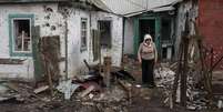 <p>Mulher caminha em casas destru&iacute;das na cidade de Debaltseve, nordeste de Donetsk, na Ucr&acirc;nia</p>  Foto: Marko Djurica / Reuters