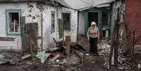 <p>Mulher caminha em casas destruídas na cidade de Debaltseve, nordeste de Donetsk, na Ucrânia</p>  Foto: Marko Djurica / Reuters