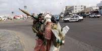 <p>Militantes patrulham rua que dá acesso ao aeroporto em Áden, no Iêmen</p>  Foto: Stringer / Reuters