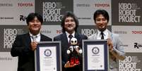 Sócios responsáveis pela criação do robô astronauta japonês Kirobo posam para fotos juntos dos certificados concedidos pelo Guinness Book  Foto: Yuya Shino / Reuters