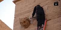 Na gravação, membros do EI usam martelos, picaretas e até fuzis kalashnikov para derrubar símbolos espalhados pelo local.   Foto: YouTube / Reprodução