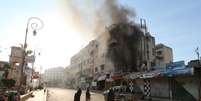 Membros da Frente Al-Nusra, grupo ligado à Al Qaeda, observam incêndio causado por curto-circuito elétrico numa rua em Idlib, na Síria, nesta segunda-feira. 06/04/2015  Foto: Ammar Abdullah / Reuters