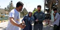 Policial afegão ajuda uma mulher após ataque em Mazar-i-Sharif, no Afeganistão, nesta quinta-feira. 09/04/2015  Foto: Stringer / Reuters