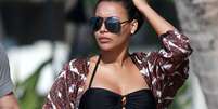 Famosa por viver Santana no seriado Glee, Naya Rivera foi fotografada em uma praia do Havaí com seu marido Ryan Dorsey. A atriz, que está grávida, usou um biquíni preto que mostrou sua barriga.  Foto: The Grosby Group