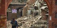 Homem chora em meio a escombros de prédios após terremoto no Nepal  Foto: Reuters