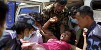 Militares e voluntários carregam uma mulher ferida ao hospital Dhading, após o terremoto de sábado, em Dhading Besi, no Nepal, nesta segunda-feira. 27/04/2015  Foto: Athit Perawongmetha / Reuters