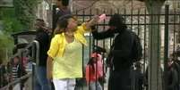 Mulher tira filho à força de protesto em Baltimore aos tapas   Foto: BBC News Brasil