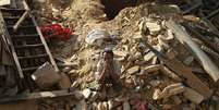 Vítima do terremoto sentado nos destroços de uma casa no vilarejo de Sindhupalchowk  Foto: Adnan Abidi / Reuters